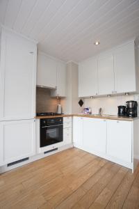 耶卢Havsdalsgrenda Geilo Apartments的白色的厨房配有白色橱柜和木地板