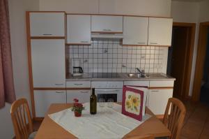 阿皮亚诺苏拉斯特拉达Ansitz Weissenheim的厨房配有带1瓶葡萄酒的桌子