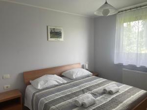 塞扎纳Apartma pri Cesarjevih的一间卧室配有一张床,上面有两条毛巾