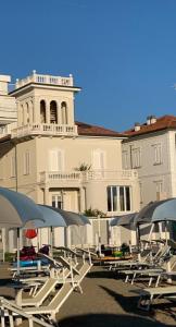 里米尼Villa La Torretta Luxury B&B - Adults Only -的一组椅子和遮阳伞在建筑前