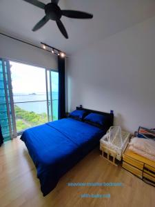 峇六拜Infinite Seaview with Penang Bridge Suite with Sunrise up to 11 person的一间卧室配有蓝色的床和吊扇