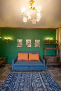 清迈Mana-An Lake Hill Resort Villa的绿色墙壁的房间里一张蓝色的沙发