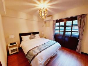 台北阳明温泉度假村的一间卧室配有一张大床和一个吊灯。