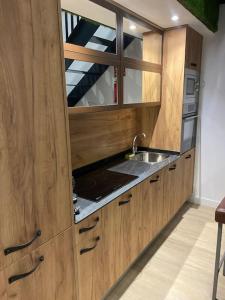 马德里Moderno loft en Barajas的一个带木制橱柜和水槽的厨房