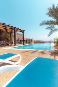 索瓦马Little Venice Chalet- Private Villa- Dead Sea Jordan的度假村内的一个蓝色海水游泳池