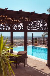 索瓦马Little Venice Chalet- Private Villa- Dead Sea Jordan的享有游泳池的景色,游泳池设有凉亭、桌子和长凳