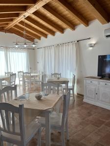 西尼斯科拉Sa Jacca Albergo Rurale的一间带桌椅和电视的用餐室