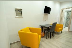福尔米亚Domus Martì的客厅配有桌子和黄色椅子