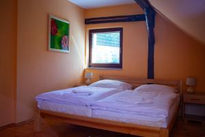 莱沃恰Apartmán NIKA的一间卧室配有一张带白色床单的床和一扇窗户。