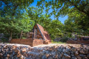 伊莫茨基Rock Oak Camping的一座带栅栏和树木的小木结构建筑