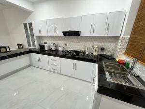 Ratmalana SouthLuxury 2BR Apartment in Ratmalana的厨房配有白色橱柜和黑色台面