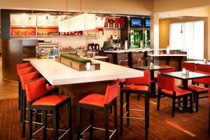 赫兰德霍兰托莱多机场万怡酒店的餐厅内的酒吧,带红色椅子