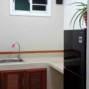 Mem Homestay的厨房配有水槽和黑冰箱。