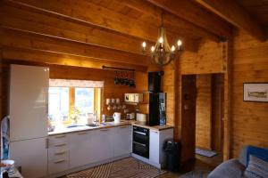 斯沃弗姆Bishy Barnabees country lodge with hot tub的厨房设有木墙和炉灶烤箱。