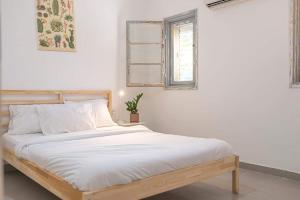 舍亚尔雅舒弗מקום לנשום בית אירוח的白色的卧室配有白色床单和窗户