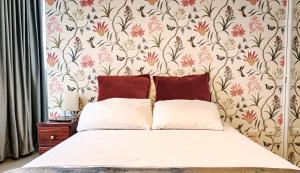 萨利纳斯C&E Departamento , a una calle de la PLAYA & MALECÓN的一间卧室配有一张带花卉壁纸的床