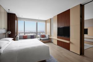 沈阳沈阳万豪酒店的配有一张床和一台平面电视的酒店客房