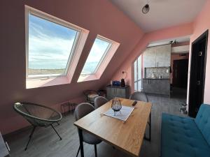 巴尔奇克Sea Sky View Apartments的一间带桌椅和2扇窗户的用餐室
