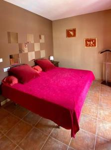 埃尔博斯克CASA RURAL EN URB LAs TRUCHAS-EL BOSQUE的一间卧室配有一张带粉色毯子的大床