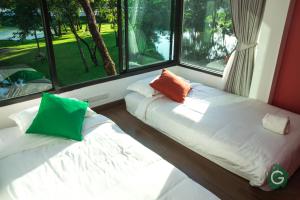 武里南武里南府格林酒店的配有窗户的客房内的两张床