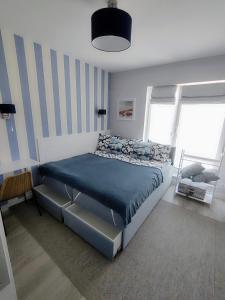 库瑞尼卡慕斯卡Luksusowy Apartament Stella - Port Krynica Morska的一间卧室配有一张带蓝色棉被的床