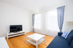 派尔努Ringi Apartments的客厅配有蓝色的沙发和电视