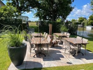 哈林亨Harlingen Staete Wellness B&B Oase van rust en luxe的河畔的庭院配有木桌和椅子