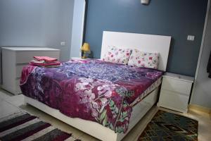卢克索Villa Rebecca的一间卧室配有一张带紫色毯子和枕头的床。