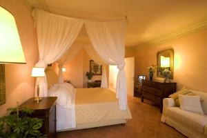 锡耶纳依波娜坎伯吉奥瑞拉斯酒店的一间卧室配有天蓬床和沙发