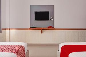 BanjarbaruOYO 92518 De Luna Hotel的客房设有两张床和一台平面电视。