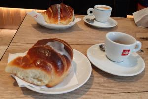 圣贝内代托-德尔特龙托Appartamento Nautes的一张桌子,上面放着两盘面包和一杯咖啡