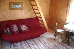 Türju rannamaja的客厅里设有一张红色的沙发,设有楼梯