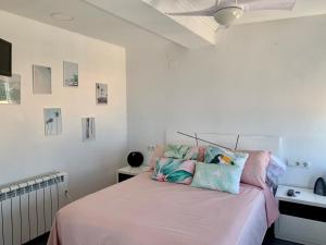 甘迪亚海滩Apartamento Bonaire-primera linea playa的一间卧室配有一张带粉色床单和枕头的床。