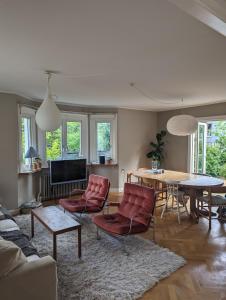 哥德堡30-tals villa med närhet till centrala GBG的客厅配有红色椅子和桌子