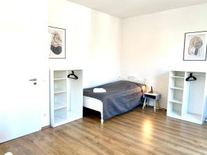 杜伊斯堡2 Rooms, free Parking, 25 min to Düsseldorf, 150 Mbps WLAN的一间卧室设有床铺、白色墙壁和木地板