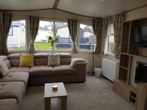 米尔福德昂西2 Bedroom Lodge, Milford on Sea的带沙发和电视的客厅
