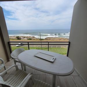乌旺戈海滩Driftsands Sea View Flats的海景阳台上的桌椅