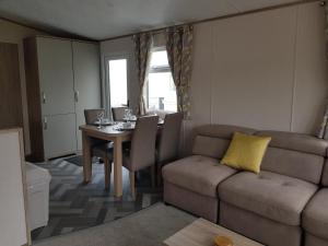 米尔福德昂西2 Bedroom Lodge, Milford on Sea的客厅配有沙发和桌子