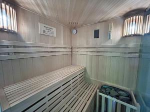 大舍瑙Ferienwohnung Ornella mit Sauna, Whirlpool的墙上设有带长椅和时钟的桑拿浴室