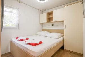 迪斯诺Beachhouse Smiley Two的小卧室配有带白色床单和红色毛巾的床