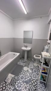 里斯本SÓLO HABITACIÓN GRANDE CON BALCOn的带浴缸、盥洗盆和卫生间的浴室