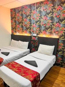 伯恩仓Hotel Citra的一张带花卉壁纸的客房内的两张床