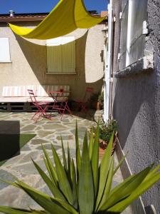 菲里亚尼Casa Davia. Studio indépendant meublé.的天井配有黄色雨伞和桌椅