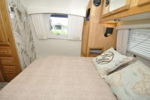 埃尔讷沃德Airstream Retro USA caravan的小卧室配有一张位于走廊的床铺