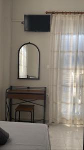 伊奥斯乔拉Andromeda的一间卧室配有镜子、梳妆台和窗户