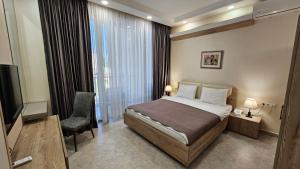 第比利斯MD Apart Hotel Tbilisi的酒店客房,配有床和电视