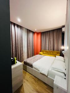 都拉斯Colombia Apartments&Rooms的一间卧室配有一张带橙色墙壁的大床
