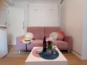 内尔哈Marixa Room的客厅配有粉红色的沙发和桌子