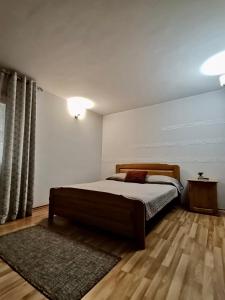 杜劳Pensiunea Lu' Movila的一间卧室配有一张大床和地毯。