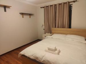 阿马代尔The Cozy little House的卧室配有白色的床和毛巾